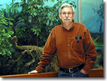 Dick Hilton in front of the dinosaur display